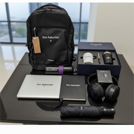 Black branded laptop backpack shown with notebooks, headphones and accessories
